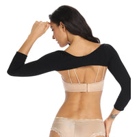 Femme portant la Gaine Bras et Dos noire sculptant les bras et améliorant la posture avec confort et élégance.