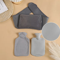 Bouillotte Tour de Taille grise en flanelle avec housse amovible, posee sur fond beige avec accessoires decoratifs