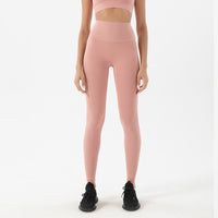 Femme qui porte un legging gainant rose pèche
