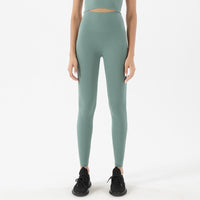 Femme adepte de yoga qui porte un legging gainant bleu gris