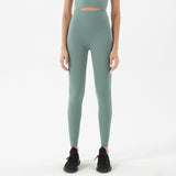 Femme adepte de yoga qui porte un legging gainant bleu gris