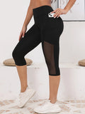 Legging Court Semi Transparent Femme noir avec empiècement mesh sur cuisses, style moderne et confort optimal pour le sport.