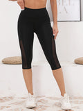 Legging Court Semi Transparent Femme noir avec panneaux en mesh sur les côtés, confort et style sportif au quotidien.