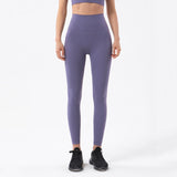 Femme qui porte un legging gainant yoga violet