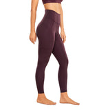 Femme de profil qui porte un Legging gainant taille haute fitness bordeau