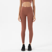 Femme qui porte un legging gainant yoga marron clair