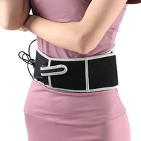 Ceinture lombaire chauffante noire avec bordure grise portee sur une tenue rose, vue laterale du produit en utilisation