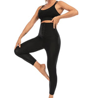 Femme en legging noir, posant en équilibre, portant le Legging de Sudation Anti Cellulite taille haute ajustée.
