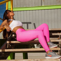 Femme qui porte un legging anti cellulite grande taille rose