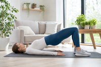 Femme réalisant un exercice de renforcement musculaire près de plantes vertes