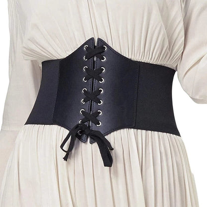Ceinture corset cuir noir avec lacets sur robe blanche plissee, ceinture large style corset sculptant la taille