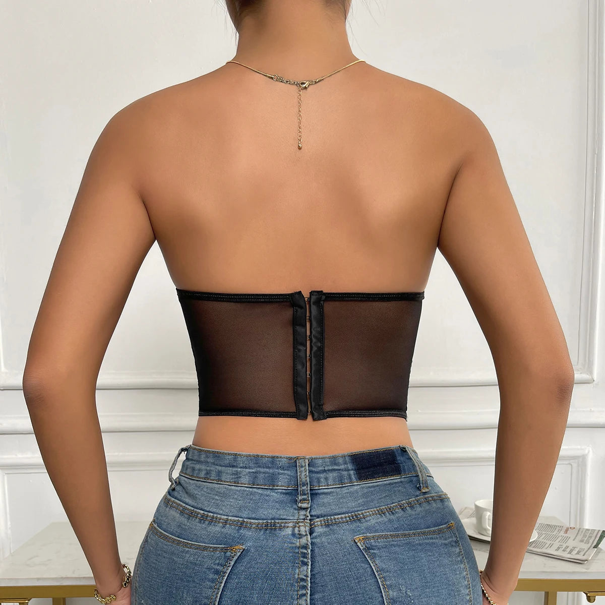 Vue de dos du Body Bustier Noir avec fermeture, portee avec un jean, montrant l'elegance et le style raffine du bustier