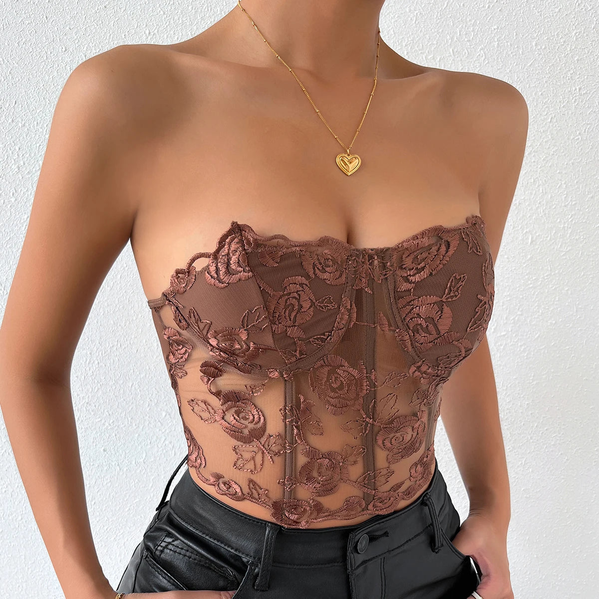 Body Bustier Noir en dentelle transparente avec motifs floraux, porte avec un collier pendentif coeur dore et jean noir